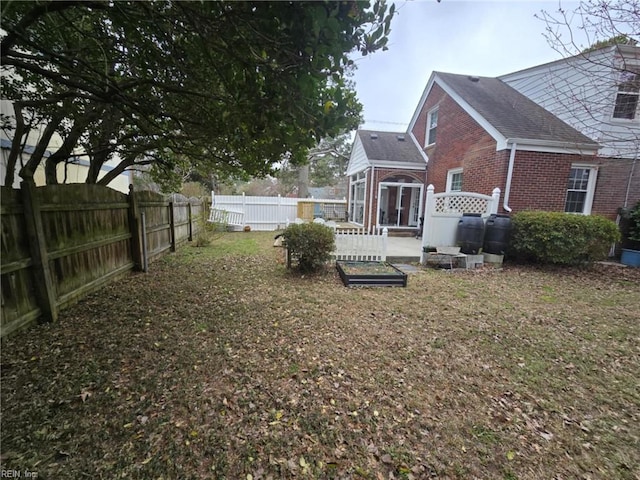 view of yard with a fenced backyard and a sunroom