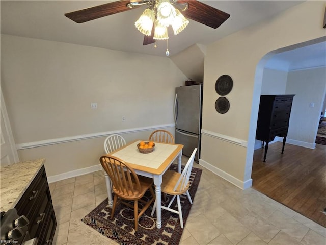 dining space featuring light tile patterned floors, baseboards, and ceiling fan