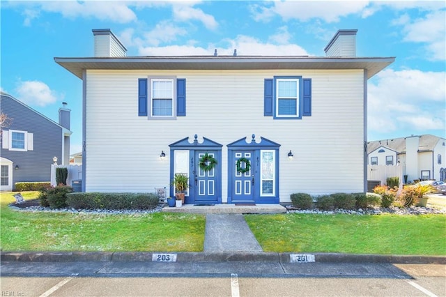 view of front of house featuring a front yard and a chimney