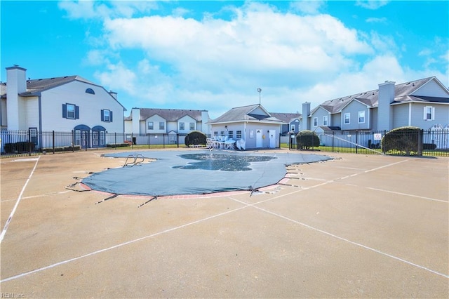 view of swimming pool featuring a residential view, a patio, and fence