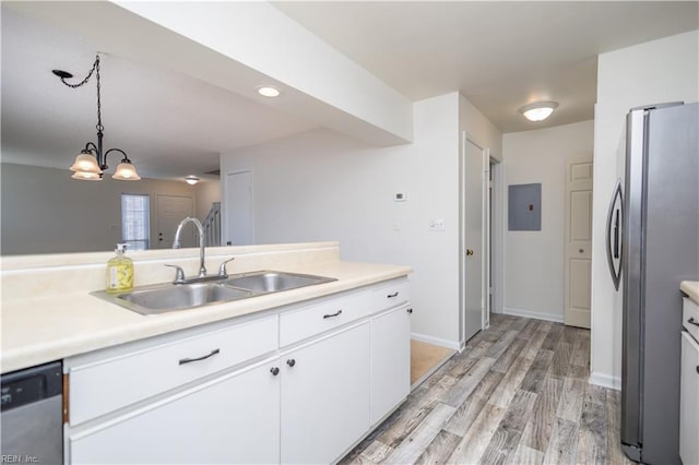 kitchen with light wood-style flooring, a sink, white cabinetry, appliances with stainless steel finishes, and light countertops