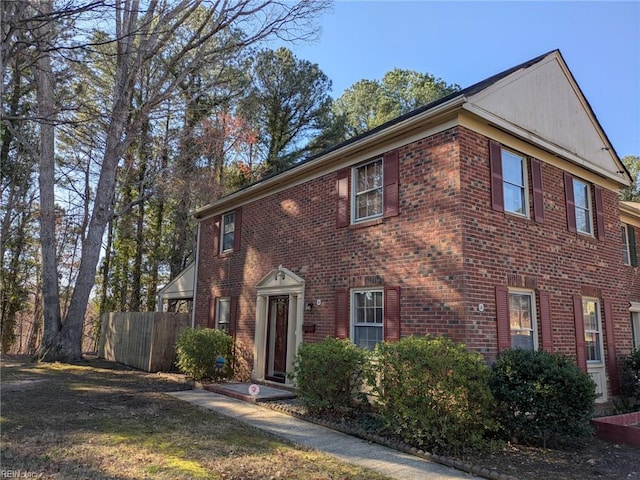 view of front of house with brick siding and fence