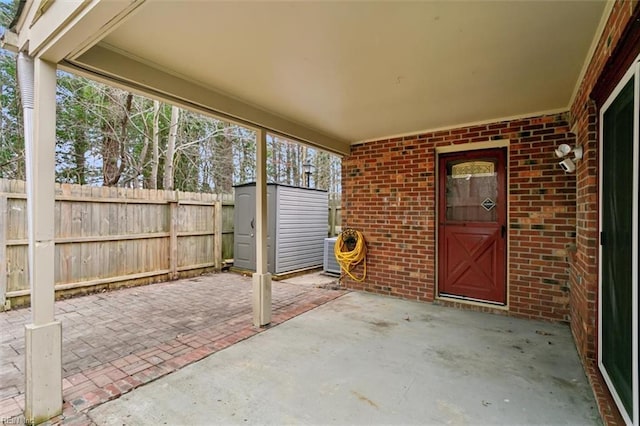 view of patio / terrace featuring a storage shed, fence, and an outdoor structure