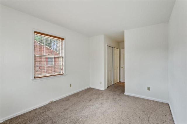 carpeted empty room with baseboards