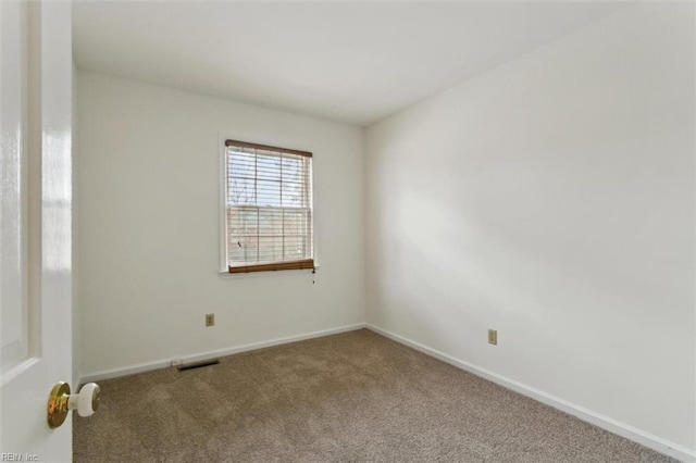 carpeted spare room featuring visible vents and baseboards