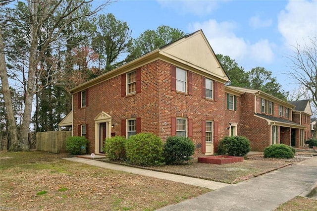 view of front of property with brick siding and fence