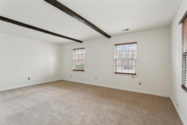 unfurnished room with beam ceiling, visible vents, light colored carpet, and baseboards