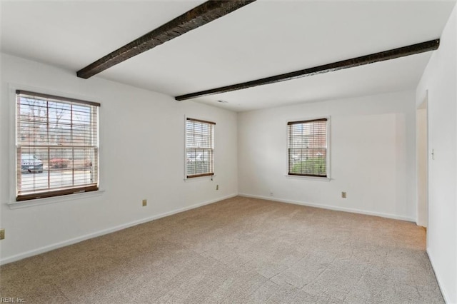 carpeted empty room featuring baseboards and beam ceiling