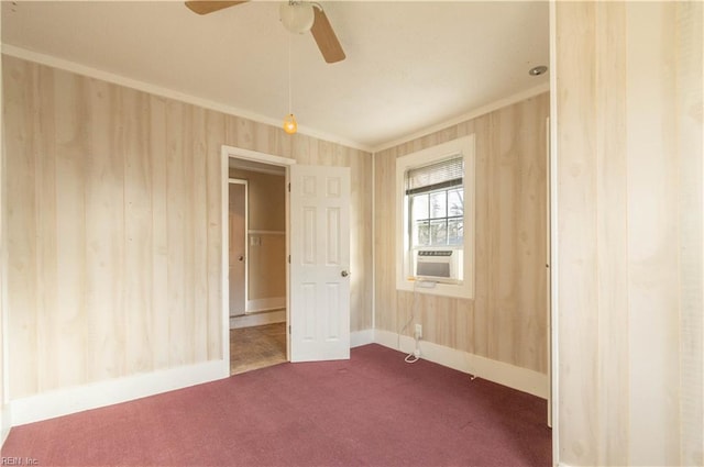 unfurnished room with cooling unit, baseboards, ceiling fan, ornamental molding, and dark colored carpet