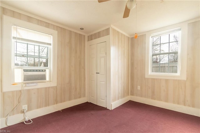 unfurnished room with cooling unit, baseboards, a ceiling fan, and dark carpet