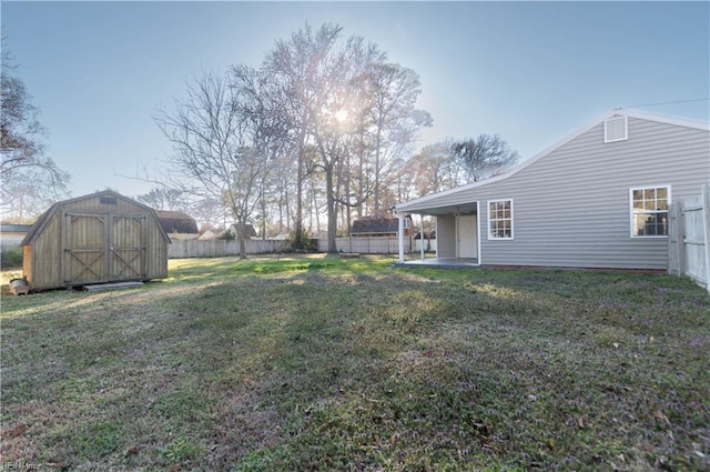 view of yard featuring an outdoor structure, fence, a shed, and a patio