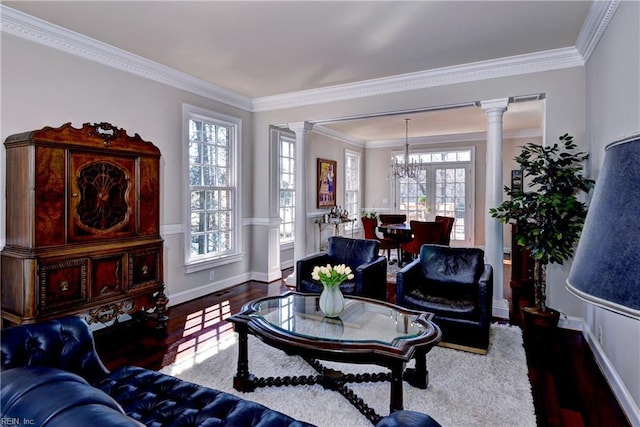 living area with plenty of natural light, wood finished floors, and ornate columns