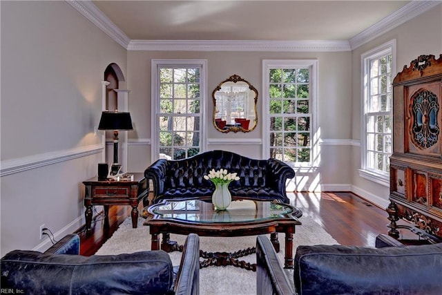 living room with crown molding, plenty of natural light, and wood finished floors