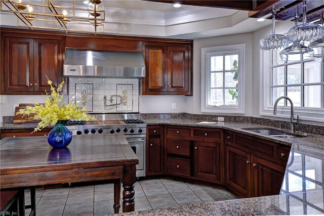 kitchen featuring high end range, ornamental molding, a sink, wall chimney exhaust hood, and tasteful backsplash