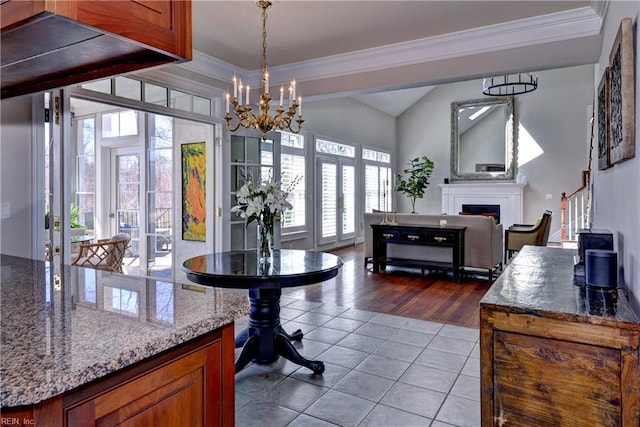 interior space featuring tile patterned floors, ornamental molding, a fireplace, a chandelier, and stairs