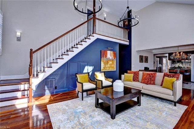 living area featuring stairway, wood finished floors, visible vents, and a chandelier