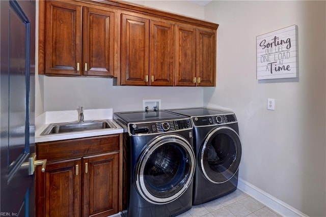 laundry room featuring light tile patterned floors, baseboards, cabinet space, a sink, and washing machine and dryer