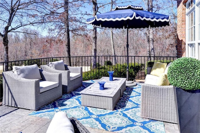 view of patio / terrace featuring an outdoor hangout area and a view of trees