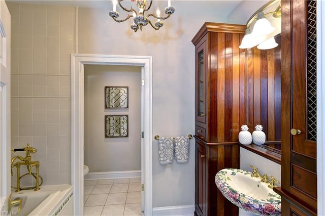 full bath with toilet, a sink, an inviting chandelier, tile patterned flooring, and baseboards