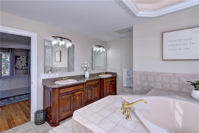 full bathroom with double vanity, a bath, tile patterned floors, and a sink