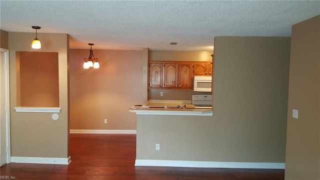 kitchen with dark wood-style floors, white microwave, baseboards, electric stove, and decorative light fixtures