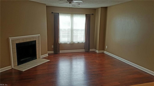 unfurnished living room featuring baseboards, a tile fireplace, wood finished floors, a textured ceiling, and a ceiling fan