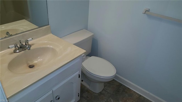 bathroom featuring baseboards, toilet, and vanity