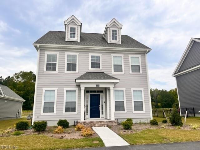 view of front of house with a shingled roof and fence