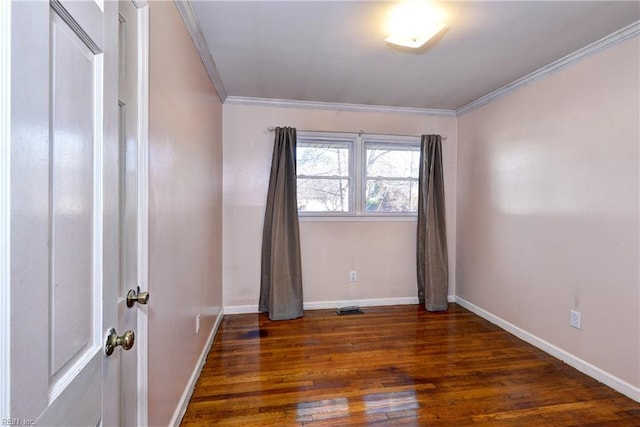 spare room featuring visible vents, crown molding, baseboards, and wood finished floors