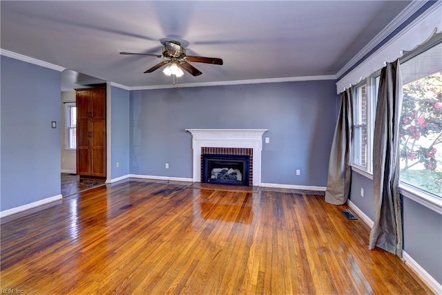 unfurnished living room with hardwood / wood-style floors, a brick fireplace, and ornamental molding