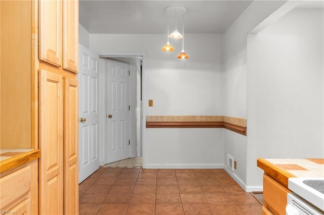 interior space with light tile patterned floors and baseboards