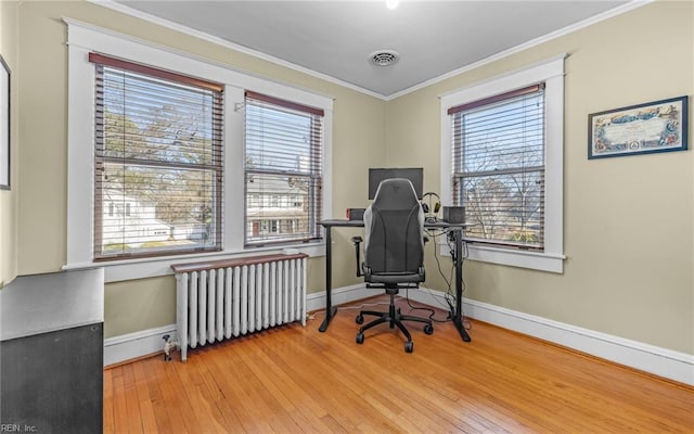 office area featuring plenty of natural light, radiator, crown molding, and wood-type flooring