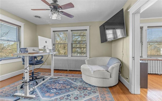 home office with radiator, visible vents, and plenty of natural light