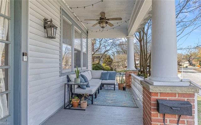 wooden deck featuring an outdoor living space, covered porch, and ceiling fan