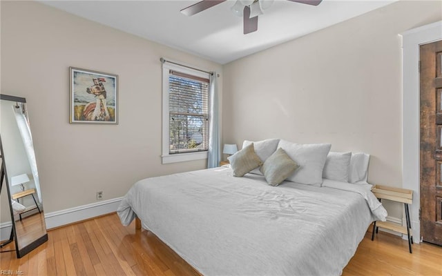 bedroom featuring baseboards, light wood-style flooring, and a ceiling fan