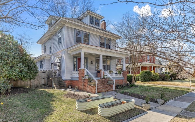 traditional style home featuring a front lawn, fence, and covered porch