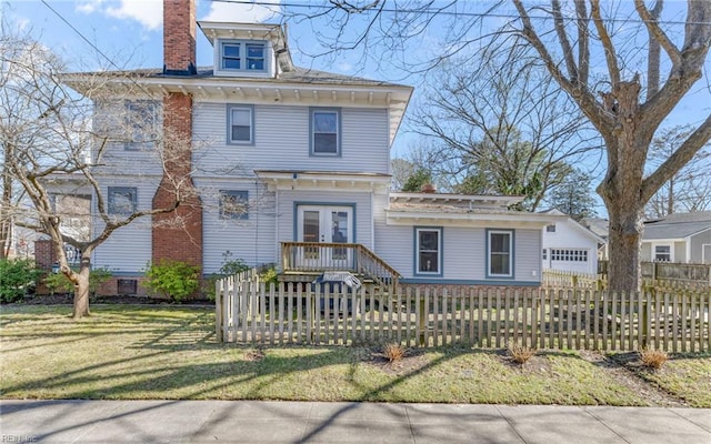 american foursquare style home with french doors, a front lawn, a fenced front yard, and a chimney