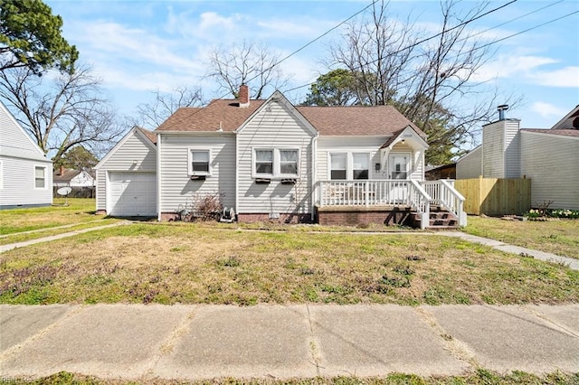 view of front of home with a front yard, driveway, a porch, a shingled roof, and a garage