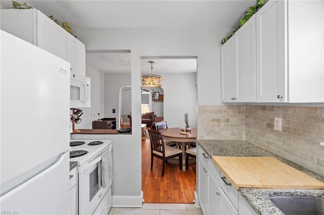 kitchen with white cabinetry, white appliances, light tile patterned flooring, and tasteful backsplash