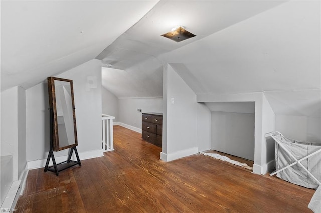 additional living space with baseboards, lofted ceiling, and wood-type flooring