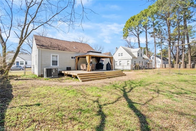 rear view of house featuring fence, a gazebo, a lawn, cooling unit, and a deck