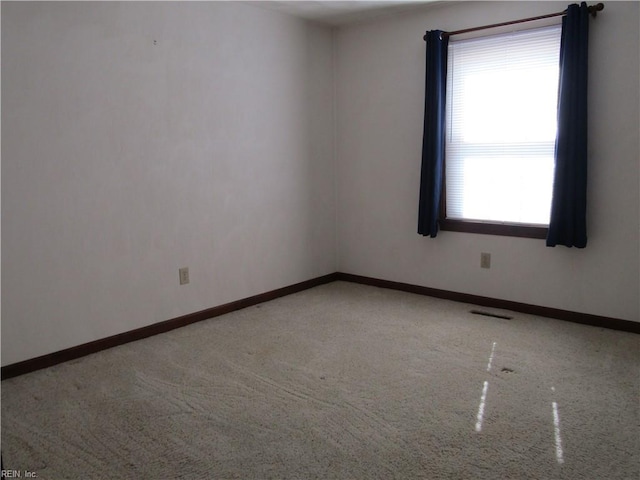 carpeted empty room with visible vents and baseboards