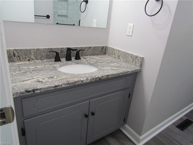 bathroom with vanity, baseboards, and wood finished floors