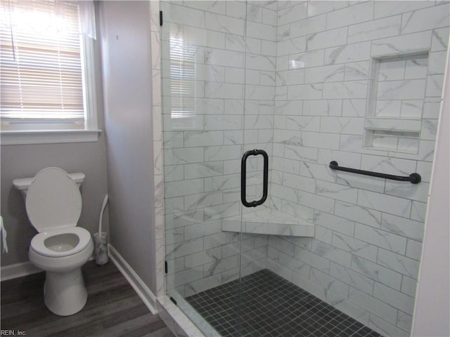 full bath with a shower stall, toilet, wood finished floors, and baseboards