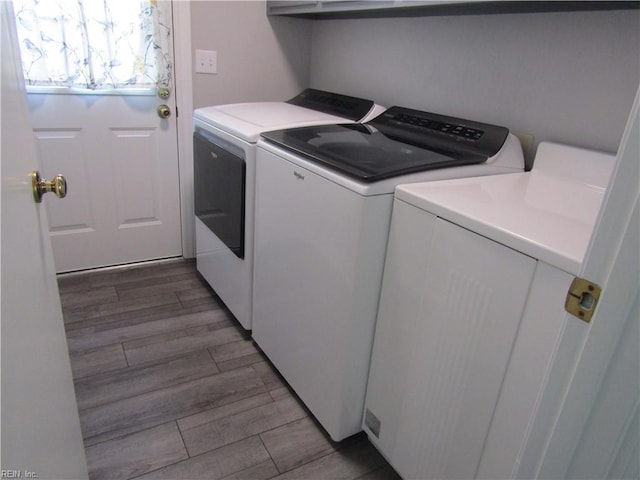 washroom with laundry area, independent washer and dryer, and light wood-type flooring