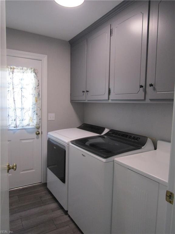 washroom with cabinet space, washing machine and dryer, and wood finished floors