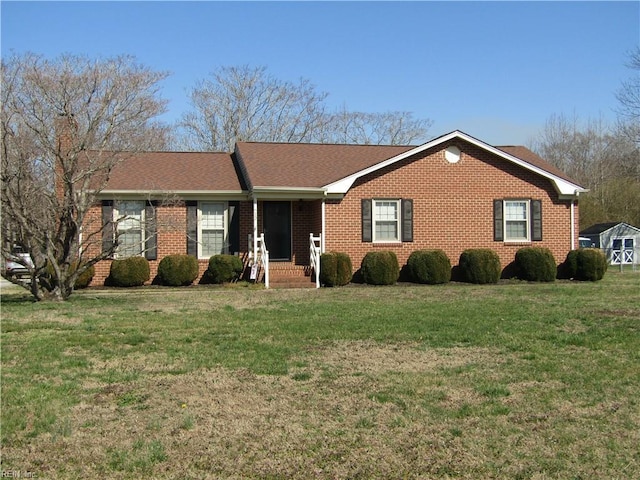 single story home featuring brick siding, a chimney, and a front lawn