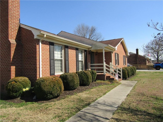 view of front of house featuring brick siding and a front lawn