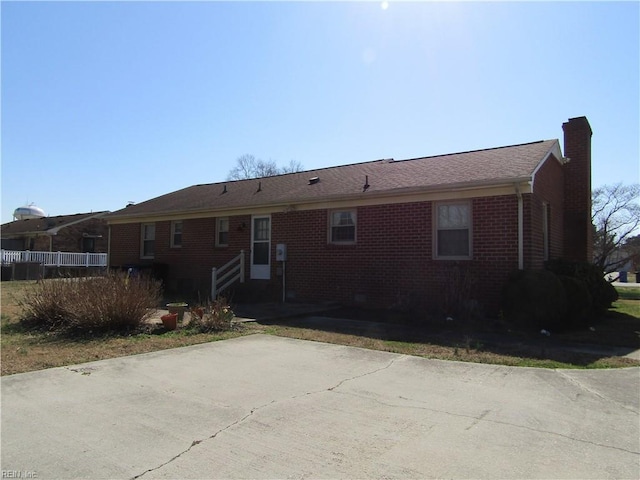 view of front of property featuring brick siding and a chimney