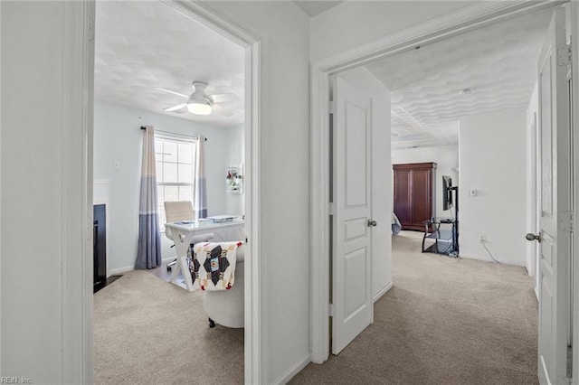 hallway with carpet and baseboards